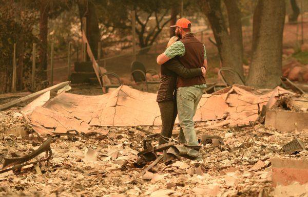 Chris and Nancy Brown embrace while looking over the remains of their burned residence after the Camp Fire tore through the region in Paradise, California on November 12, 2018. (Josh Edelson/AFP/Getty Images)