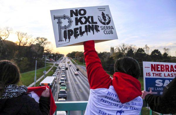 Opponents of the Keystone XL pipeline demonstrate on a pedestrian bridge during rush hour in Omaha, Neb., on Nov. 1, 2017. The pipeline was canceled by U.S. President Joe Biden immediately after he entered office in January 2021. (The Canadian Press/AP, Nati Harnik)