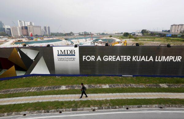 A man walks past a 1 Malaysia Development Berhad (1MDB) billboard at the funds flagship Tun Razak Exchange development in Kuala Lumpur, on March 1, 2015. (Olivia Harris/Reuters)