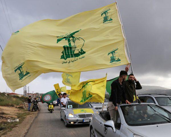 A supporter of Lebanon's Hezbollah gestures as he holds a Hezbollah flag in Marjayoun, Lebanon, on May 7, 2018. (Aziz Taher/Reuters)