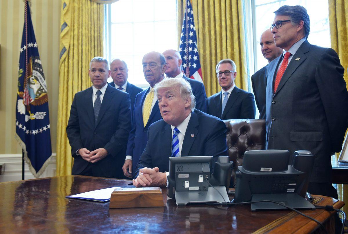 President Donald Trump announces the final approval of the XL Pipeline following a meeting with the National Economic Council in the Oval Office of the White House in Washington on March 24, 2017. At left is TransCanada CEO Russell Girling with U.S. Commerce Secretary Wilbur Ross (C). (MANDEL NGAN/AFP/Getty Images)