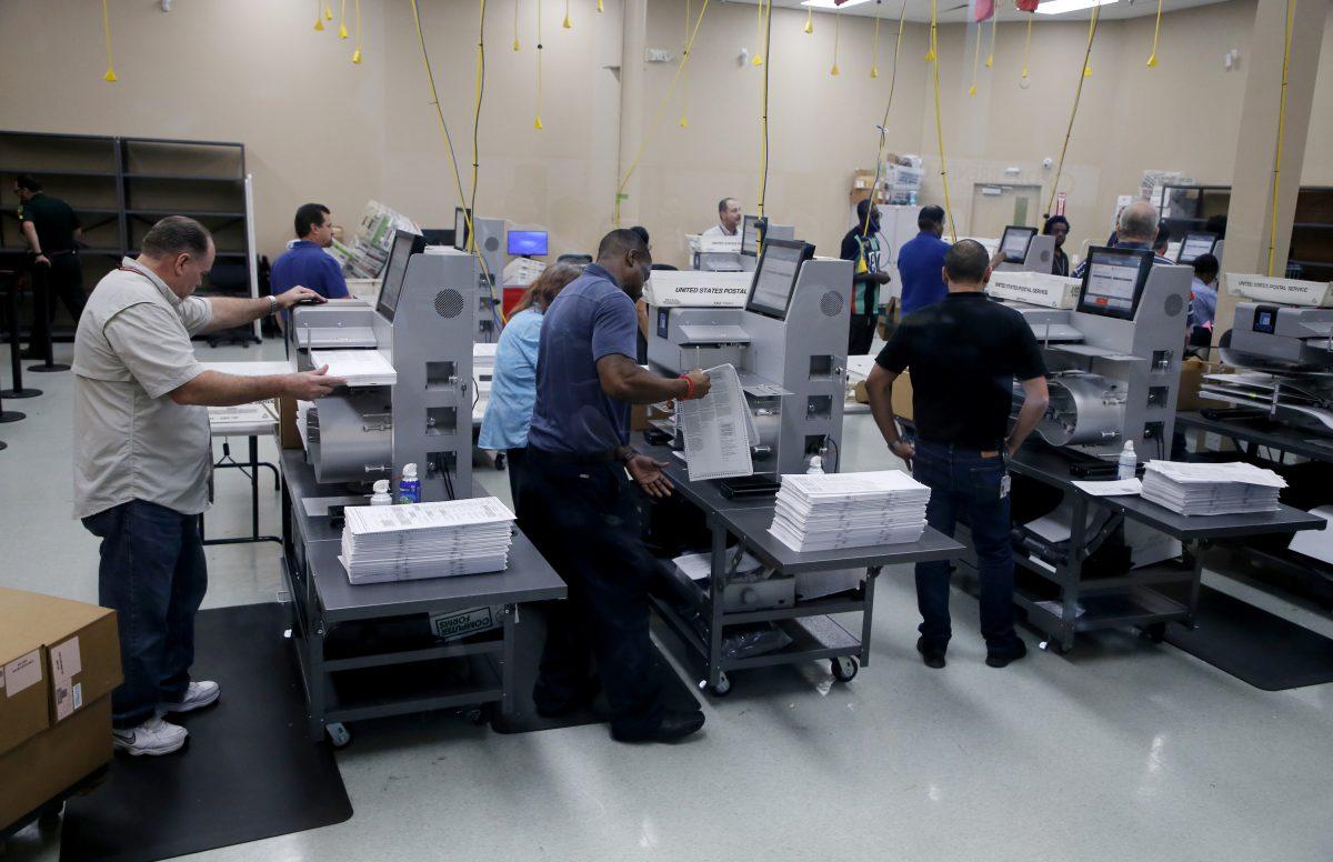 Elections staff load ballots into machines as recounting begins at the Broward County Supervisor of Elections Office in Lauderhill, Florida, on Nov. 11, 2018. (Joe Skipper/Getty Images)