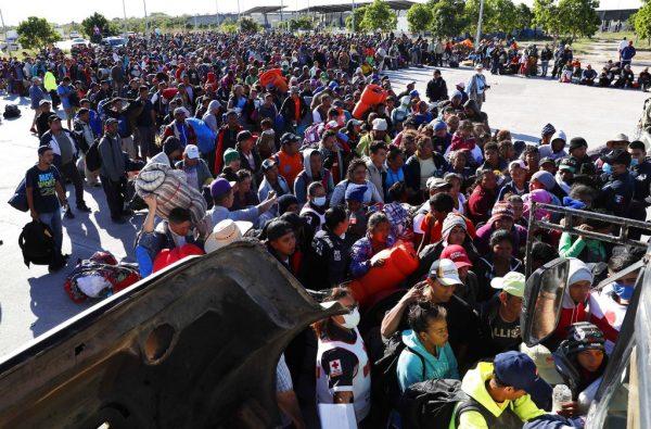 Migrants traveling with a caravan hoping to reach the United States wait in line to board buses in La Concha, Mexico, on Nov. 14, 2018. The bulk of the main caravan appeared to be about 1,100 miles from the border, but was moving hundreds of miles per day. (AP Photo/Marco Ugarte)