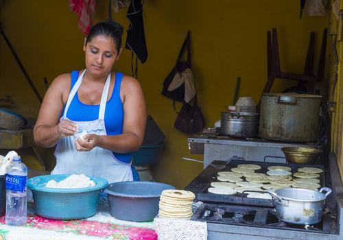 A Salvadorean woman prepares the nation's unofficial dish, pupusas. (Shutterstock)