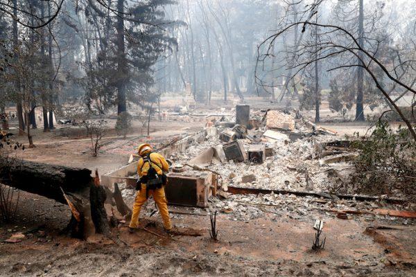 A firefighter extinguishes a hot spot in a neighborhood destroyed by the Camp Fire in Paradise, California, Nov. 13. (Reuters/Terray Sylvester)