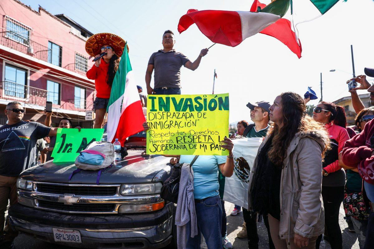 Mexicans protest the migrant caravan from Central America as riot police keep them away from the migrant encampment in Tijuana, Mexico, on Nov. 18, 2018. (Charlotte Cuthbertson/The Epoch Times)
