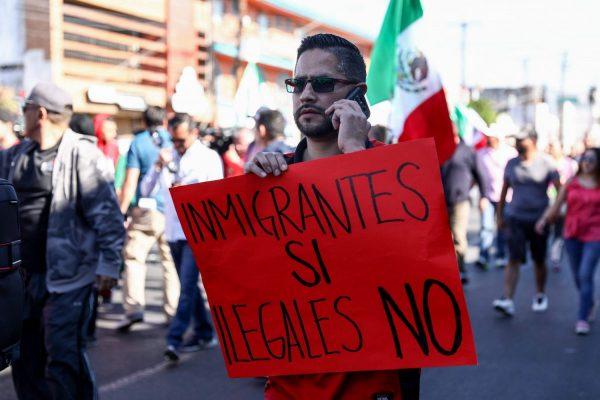 Tijuana resident Rodrigo Melgoza holds a sign that says "immigrants yes, illegals no" during a protest against the migrant caravan from Central America in Tijuana, Mexico, on Nov. 18, 2018. (Charlotte Cuthbertson/The Epoch Times)