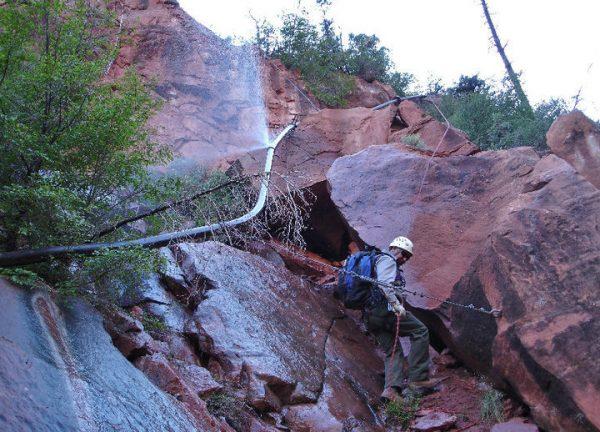 Park personnel assessing damage from a split in a section of the Trans-Canyon Waterline. (NPS)