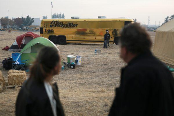 Camp Fire evacuees look at a bus titled 'The Twerkulator' that was equipped with laptops and wifi hotspots to assist people in signing up for FEMA assistance, in Chico, California, U.S. November 20, 2018. (Elijah Nouvelage/Reuters)