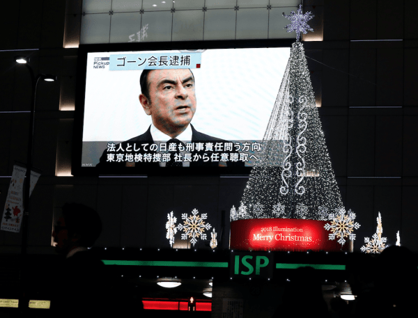 A street monitor showing a news report about arrest of Nissan Chairman Carlos Ghosn is seen next to Christmas illuminations in Tokyo, Japan Nov. 21, 2018. (Reuters/Toru Hanai)