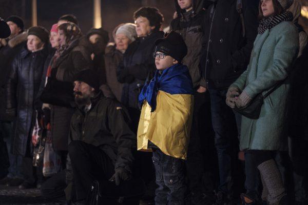 A boy listens as activists and religious leaders speak during a ceremony in Kharkiv, Ukraine, on Nov. 21, 2018, marking the five year anniversary of the Nov. 2013 protests that resulted in the ouster of President Viktor Yanukovych. (Chris Collison/Special to The Epoch Times)