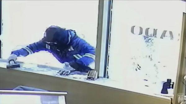 One of the would-be robbers holds a hammer as he tries to climb into a jewelry store in Mississauga, Canada, on Nov. 21, 2018. (Peel Regional Police)