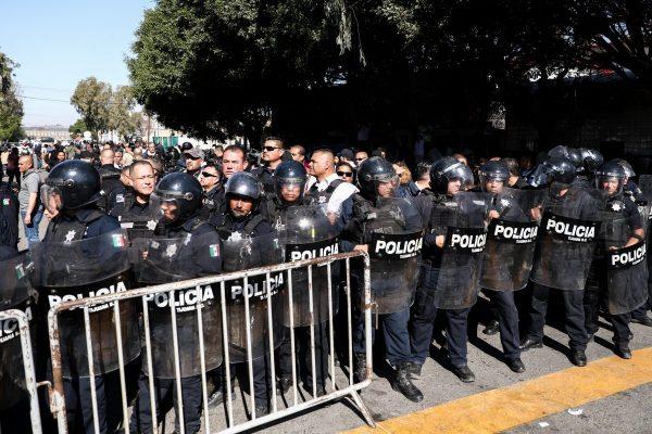 Tijuana riot police form a barrier between the migrant camp and protesting Mexicans in Tijuana, Mexico, on Nov. 18, 2018. (Charlotte Cuthbertson/The Epoch Times)