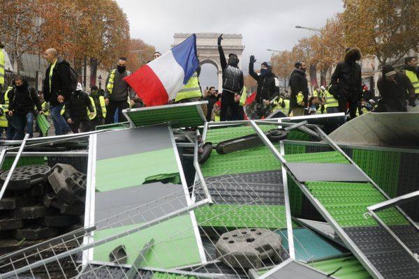 Yellow vest protesters, set up a makeshift barricade on the famed Avenue des Champs-Elysees avenue as they protest against the rising of the fuel taxes, in Paris, France, on Nov. 24, 2018. (AP Photo/Kamil Zihnioglu)