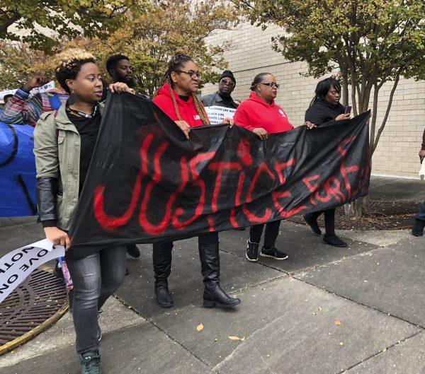 Protestors carry a sign reading “Justice for E.J.” during a protest at the Riverchase Galleria in Hoover, Ala., on Nov. 24, 2018. (Kim Chandler/AP)