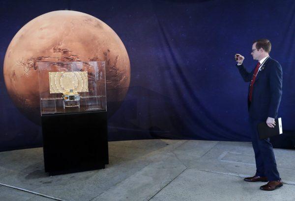 A man takes pictures of a model of the CubeSat MarCO which trails the InSight lander on its mission to Mars at NASA's Jet Propulsion Laboratory in Pasadena, Calif., on Nov. 26, 2018. (AP Photo/Marcio Jose Sanchez)