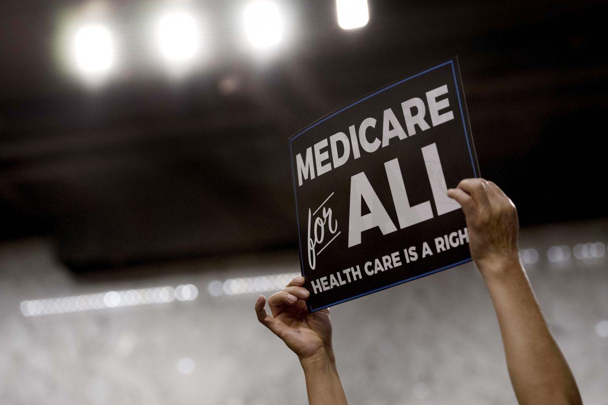 A member of the audience holds up a placard as Senator Bernie Sanders discusses Medicare for All legislation on Capitol Hill on Sept. 13, 2017. (Jim Watson/AFP/Getty Images)