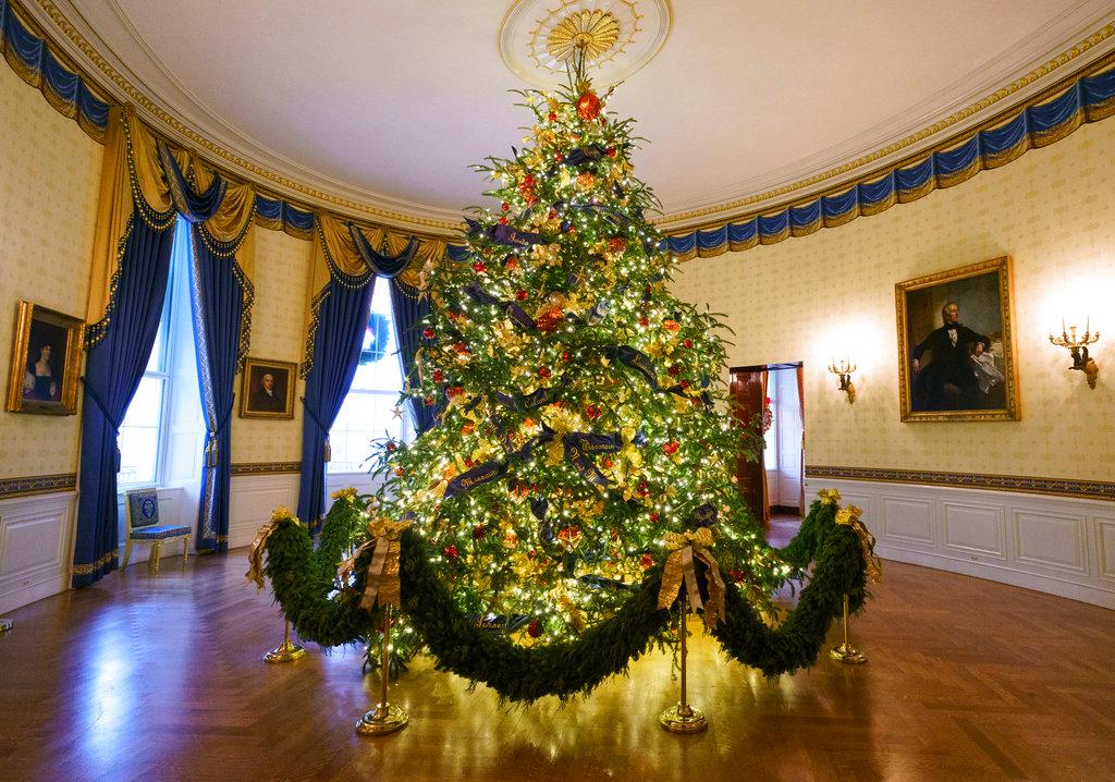The official White House Christmas tree is seen in the Blue Room during the Christmas press preview at the White House in Washington, on Nov. 26, 2018. The tree measures 18 feet tall and is dressed in over 500 feet of blue velvet ribbon embroidered in gold with each State and territory. (AP Photo/Carolyn Kaster)
