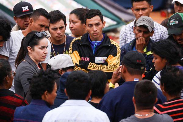Members of the Central American migrant caravan listen to Erika Pinheiro, litigation director for Al Otro Lado, instructing them on the asylum process in the United States at a municipal sports complex in Zone Norte near the U.S.-Mexico border in Tijuana, Mexico, on Nov. 19, 2018. (Charlotte Cuthbertson/The Epoch Times)