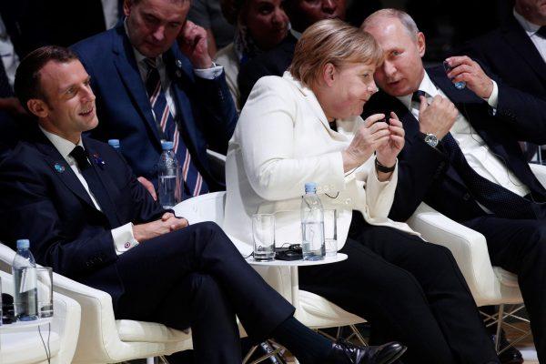 German Chancellor Angela Merkel and Russian President Vladimir Putin attend the opening ceremony of the Paris Peace Forum next to French President Emmanuel Macron in Paris on Nov. 11, 2018. (Yoan Valat/AFP/Getty Images)
