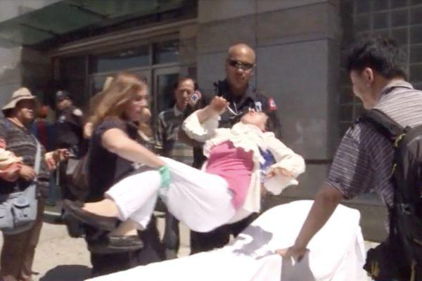 Fu Yuxia being moved to an ambulance after being assaulted outside the Chinese Consulate in New York on July 1, 2014. (television)
