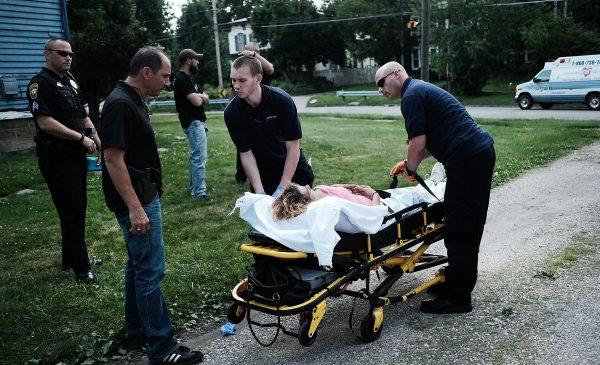 Medical workers and police treat a woman who has overdosed on heroin, the second case in a matter of minutes in Warren, Ohio, on July 14, 2017. (Spencer Platt/Getty Images)