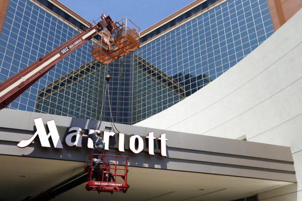 A man works on a new Marriott sign in front of the former Peabody Hotel in Little Rock, Ark., on April 30, 2013. (AP Photo/Danny Johnston, File)
