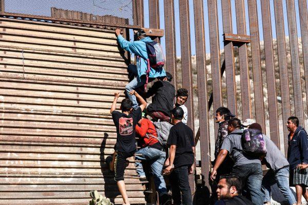 Migrants break through the U.S. border fence just beyond the eastern pedestrian entrance of the San Ysidro crossing in Tijuana, Mexico, on Nov. 25, 2018. (Charlotte Cuthbertson/The Epoch Times)