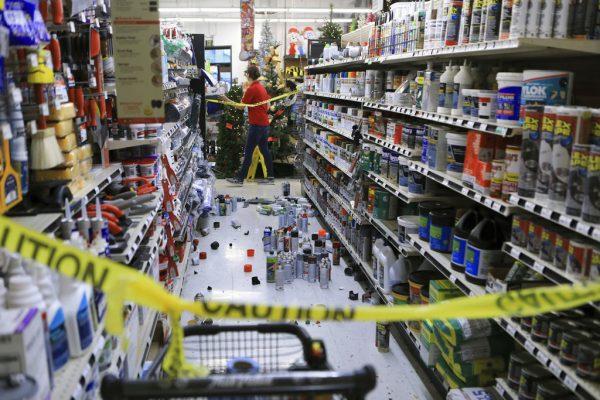 An employee walks past a damaged aisle at Anchorage True Value hardware store after an earthquake in Anchorage, Alaska, on Nov. 30, 2018. (AP Photo/Dan Joling)