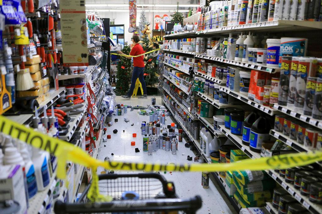 An employee walks past a damaged aisle at Anchorage True Value hardware store after an earthquake in Anchorage, Alaska, on Nov. 30, 2018. (AP Photo/Dan Joling)