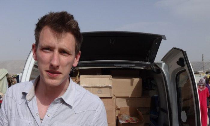 Peter Kassig stands in front of a truck filled with supplies for Syrian refugees. A graphic video produced by ISIS terrorists in Syria released on Nov. 16, 2014 claimed U.S. aid worker Kassig was beheaded. (AP Photo/Courtesy Kassig Family)