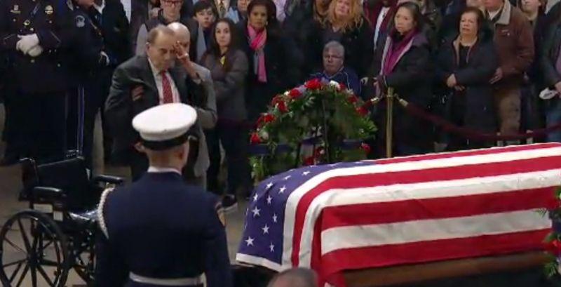 Former Republican Sen. Bob Dole seen being assisted out of his wheelchair to pay his respects with a salute to the late former President George H.W. Bush on Dec. 4. (CNN)