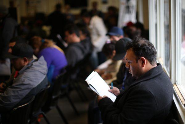 An applicant fills out paperwork for health insurance at an enrollment fair at the Bay Area Rescue Mission in Richmond, Calif., on March 31, 2014. (Photo by Justin Sullivan/Getty Images)