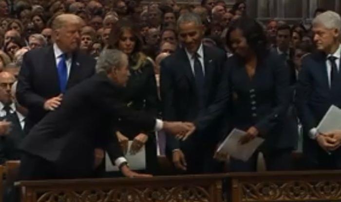 Video: George W. Bush Appears to Give Michelle Obama Candy During Funeral