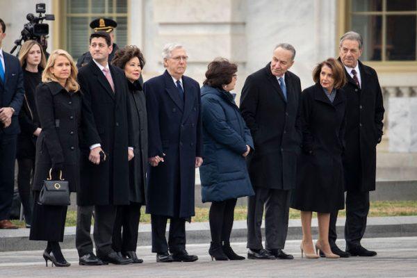 (L-R) Janna Ryan, Speaker of the House Paul Ryan, Transportation Secretary Elaine Chao, Senate Majority Leader Mitch McConnell, Iris Weinshall, Senate Minority Leader Chuck Schumer, House Minority Leader Nancy Pelosi, and Paul Pelosi await the departure of the flag-draped casket of the late former President George H.W. Bush at the U.S. Capitol in Washington, on Dec. 5, 2018. (Drew Angerer/Getty Images)