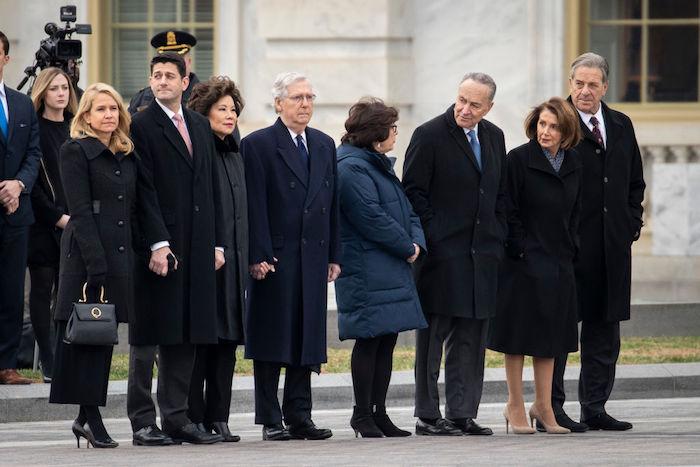 (L-R) Janna Ryan, Speaker of the House Paul Ryan, Transportation Secretary Elaine Chao, Senate Majority Leader Mitch McConnell, Iris Weinshall, Senate Minority Leader Chuck Schumer, House Minority Leader Nancy Pelosi, and Paul Pelosi await the departure of the flag-draped casket of the late former President George H.W. Bush at the U.S. Capitol in Washington, on Dec. 5, 2018. (Photo by Drew Angerer/Getty Images)