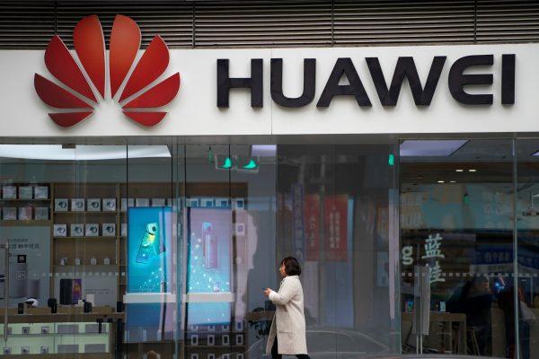 A woman walks by a Huawei logo at a shopping mall in Shanghai, China on Dec. 6, 2018. (Aly Song/Reuters)