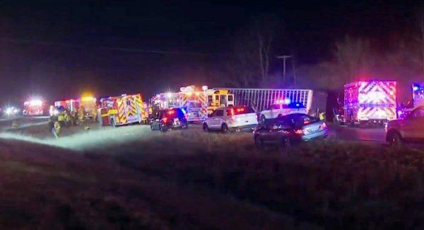 This frame grab from video by WEEK/WHOI shows emergency vehicles at the scene where a semitrailer heading the wrong way on an interstate collided head-on with a school bus carrying members of an Illinois high school girls' basketball team near Downs, Ill., late on Dec. 5, 2018. (WEEK/WHOI via AP)