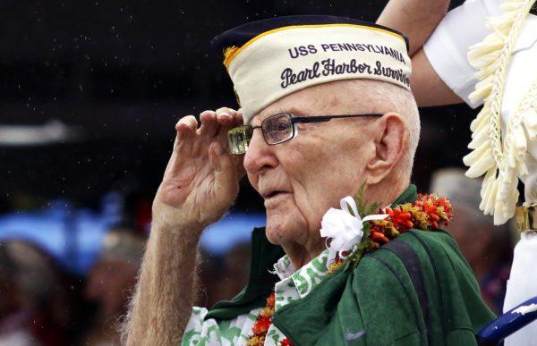 Everett Hyland, who survived the attack on Pearl Harbor as a crew member of the USS Pennsylvania, salutes on Dec. 7, 2018, as the USS Michael Murphy passes in Pearl Harbor, Hawaii during a ceremony marking the 77th anniversary of the Japanese attack. (AP Photo/Audrey McAvoy)