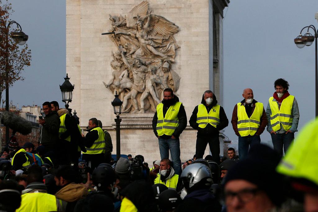 Demonstrators stand near the Arc de Triomphe on the Champs-Elysees avenue Saturday, Dec. 8, 2018 in Paris. (AP Photo/Rafael Yaghobzadeh)