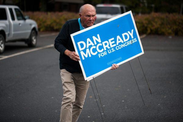 A campaign volunteer for Democratic US House candidate, Dan McCready, carries signs on November 6, 2018, in Charlotte, N.C. (Logan Cyrus/AFP/Getty Images)