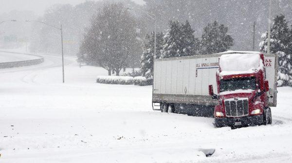 A tractor trailer is stuck on an off-ramp from Business I-40 on to Stratford Road, US 158, as snow falls in Winston-Salem, N.C., on Dec. 9, 2018. (Walt Unks/Winston-Salem Journal/AP)