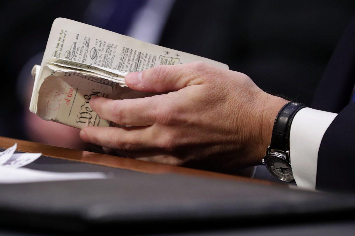 Supreme Court nominee Judge Brett Kavanaugh thumbs through a well-worn, pocket-sized copy of the U.S. Constitution as he testifies before the Senate Judiciary Committee on the second day of his confirmation hearing on Capitol Hill in Washington on Sept. 5, 2018. (Chip Somodevilla/Getty Images)