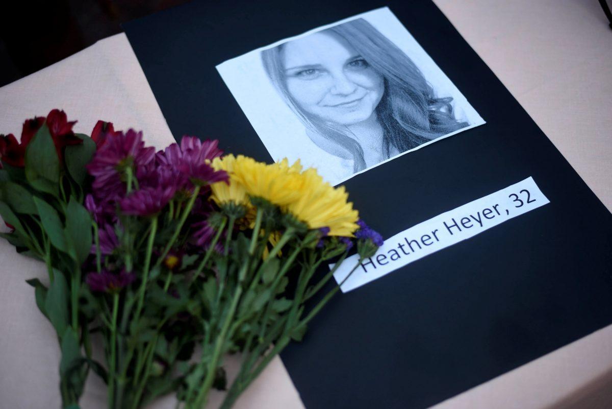A portrait of Heather Heyer, who was killed when a vehicle drove through counterprotesters in Charlottesville, Va., lies on a table with flowers during a vigil on the campus of the University of Southern Mississippi in Hattiesburg, Miss., on Aug 14, 2017. (Courtland Wells/The Vicksburg Post via AP)