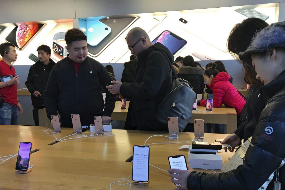People buy the latest iPhone while others try out its latest model at an Apple Store in Beijing on Dec. 11, 2018. The Chinese communist regime has adopted its ambitious tech manufacturing domination strategy under "Made in China 2025." (Andy Wong/AP Photo)