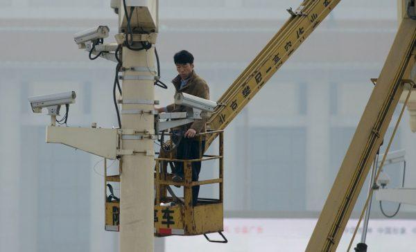 File photo showing a man checking security cameras at Tiananmen Square in Beijing, Oct. 31, 2013. (Ed Jones/Getty Images/AFP)