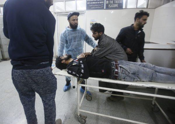 Kashmiri men wheel in an injured civilian on a stretcher inside a hospital in Srinagar, Indian controlled Kashmir, on Dec. 15, 2018. (Mukhtar Khan/AP)