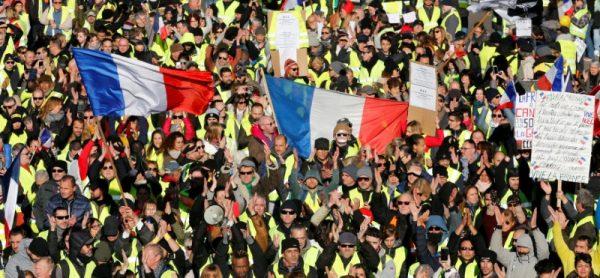 Protesters wearing yellow vests wave French flags as they take part in a demonstration of the "yellow vests" movement in Marseille, France, Dec. 15, 2018. (Reuters/Jean-Paul Pelissier)