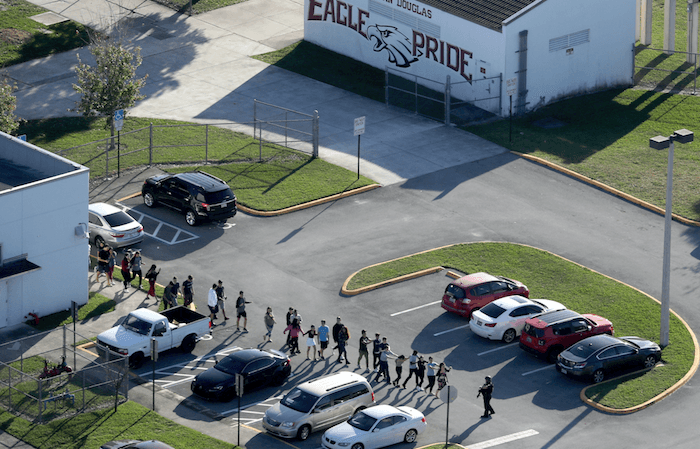 Students are evacuated by police from Marjory Stoneman Douglas High School in Parkland, Fla., after a shooter opened fire on the campus, on Feb. 14, 2018. (Mike Stocker/South Florida Sun-Sentinel via AP)