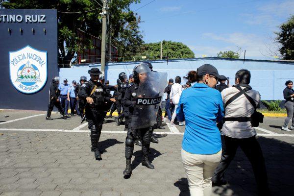 Riot police move against journalists at the entrance to police headquarters in Managua, Nicaragua, Dec. 15, 2018. (Reuters/Oswaldo Rivas)